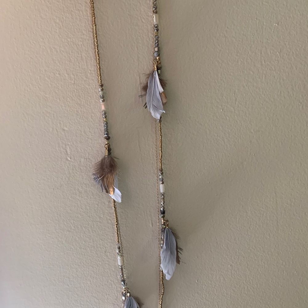 Beautiful gold necklace with beads and feathers